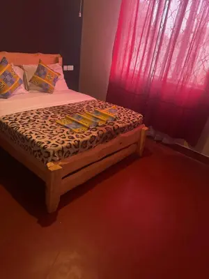 a bed in a room with a red window at Woodland villa in Arusha