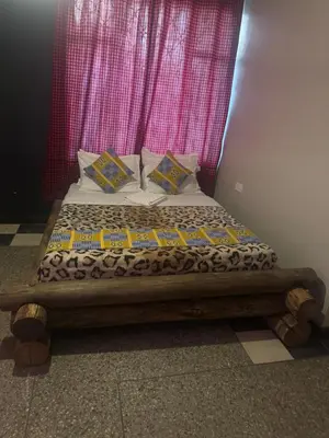 a bed in a room with a pink curtain at Woodland villa in Arusha
