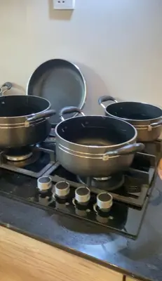 a stove with three pots and pans on it at Ellys home Arusha in Arusha