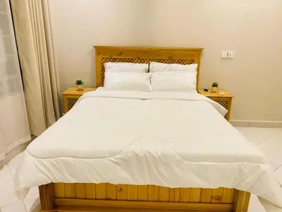 a bedroom with a large bed with white sheets and pillows at Ellys home Arusha in Arusha