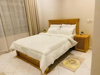 a bedroom with a large bed with white sheets and pillows at Ellys home Arusha in Arusha