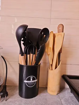 a black cup filled with lots of wooden utensils at Rest Stop Home in Arusha