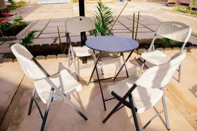 three white chairs and a blue table and chairs at Ezma-homes in Boma la Ngombe