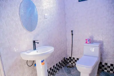 a bathroom with a white toilet and a sink at Ezma-homes in Boma la Ngombe