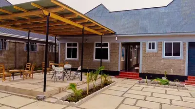 a house with a patio with tables and chairs at Ezma-homes in Boma la Ngombe
