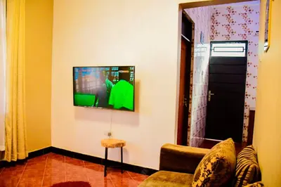 a living room with a tv on the wall at Ezma-homes in Boma la Ngombe