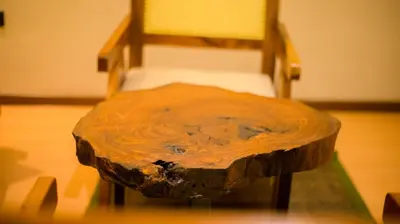 a wooden chair sitting next to a wooden table at The Valley Retreat in Arusha