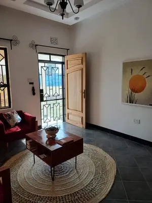 a living room with a coffee table and a door at Zebra Homestay in Mto wa Mbu