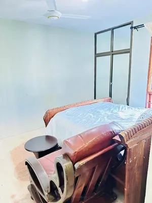 a bedroom with a bed with a stool on it at KL shadow homes in Arusha