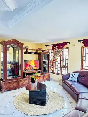 a living room with a couch and a tv at KL shadow homes in Arusha