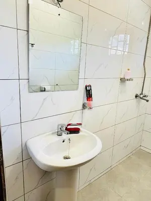 a bathroom with a white sink and a mirror at KL shadow homes in Arusha