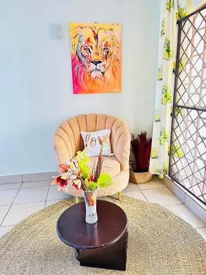 a living room with a chair and a vase of flowers at KL shadow homes in Arusha