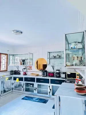 a kitchen with white cabinets and blue counters at KL shadow homes in Arusha