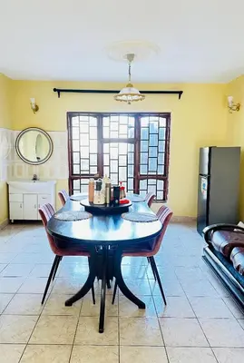 a dining room with a table and a refrigerator at KL shadow homes in Arusha