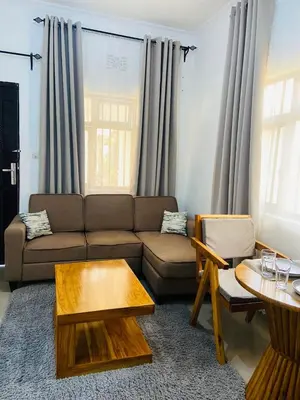 a living room with a couch and a table at Chama Haven Appartments in Tengeru
