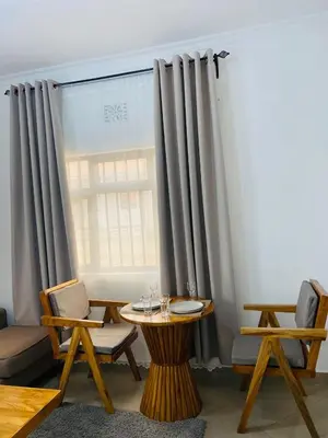 a room with a table and chairs and a window at Chama Haven Appartments in Tengeru
