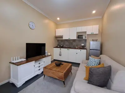 a living room with a couch and a kitchen at Mboyahomes in Arusha