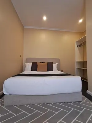 a bedroom with a large white bed in a room at Mboyahomes in Arusha