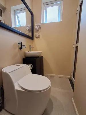 a bathroom with a white toilet and a sink at Mboyahomes in Arusha
