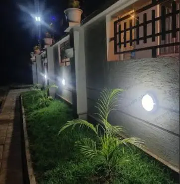 a house with lights on the side of it at night at Five Zones - Private 4-Bedroom Holiday Home in Moshi