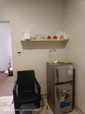 a room with a chair and a small refrigerator at Five Zones - Private 4-Bedroom Holiday Home in Moshi
