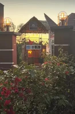 a garden with roses in front of a house at Kilimanjaro Forest Lodge and Camping Site in Mdawi