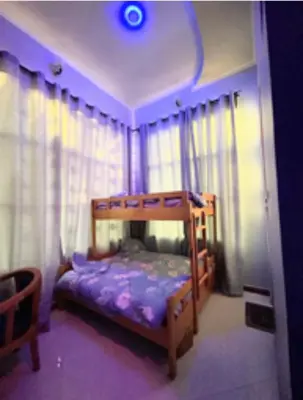 a bedroom with a wooden bunk bed with curtains at Kilimanjaro Forest Lodge and Camping Site in Mdawi