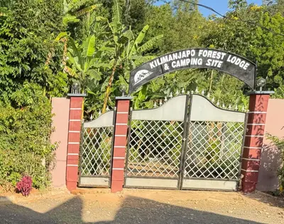 a gate with a sign that readsulum forest lodge it camping site at Kilimanjaro Forest Lodge and Camping Site in Mdawi