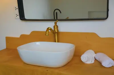 a sink with a faucet and towels on a counter at Heart Of Africa Lodge Acacia in Mkulat