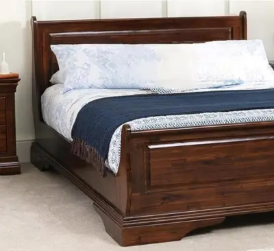 a bed with a wooden bed frame with a blue blanket at Bibi Cosy Cottage in Moshi