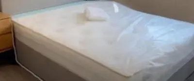 a white bed with a white sheet on it at Bibi Cosy Cottage in Moshi
