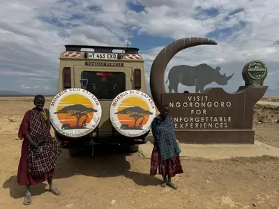 three people standing in front of a truck in the desert at Morris Eco Safaris in Arusha