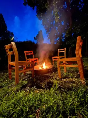two chairs sitting around a fire in the grass at NgareSero Haven - Eco 3BR Home with Garden and Farm in Usa River