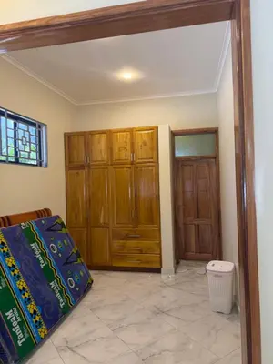 a bedroom with wooden cabinets and a door at Safari Haven Villa in Moshi