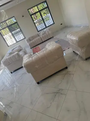 a living room with two couches wrapped in plastic at Safari Haven Villa in Moshi