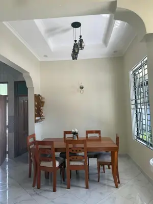 a dining room with a wooden table and chairs at Safari Haven Villa in Moshi