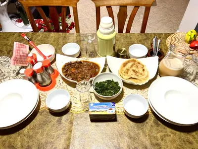 a table with white plates and food on it at Esther Villas Home in Boma la Ngombe