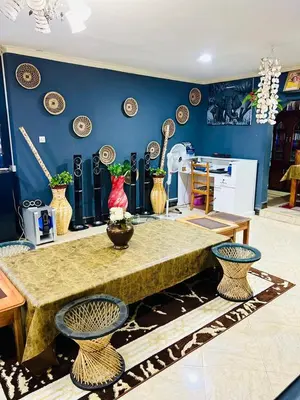 a room with a table with vases on the wall at Esther Villas Home in Boma la Ngombe