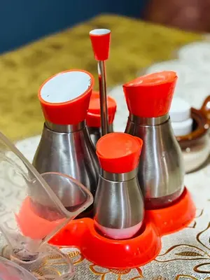 a group of red and silver kettles on a table at Esther Villas Home in Boma la Ngombe