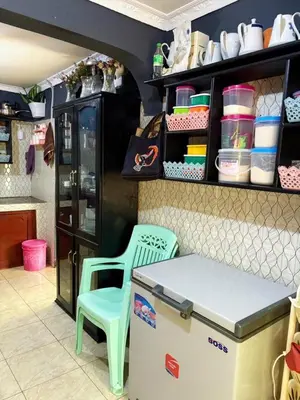 a kitchen with a table and a chair and a counter at Esther Villas Home in Boma la Ngombe