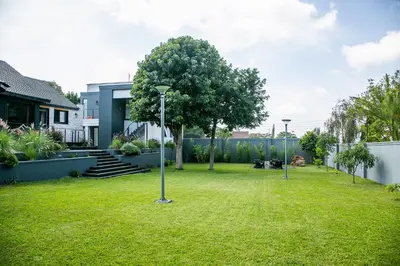 a yard with two light poles in the grass at French Unit - ground floor sleeps 2 in Arusha
