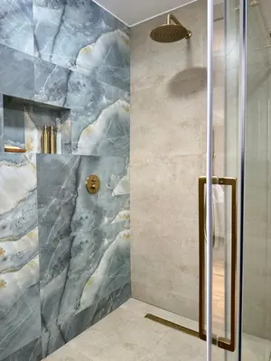 a shower in a bathroom with a marble wall at French Unit - ground floor sleeps 2 in Arusha