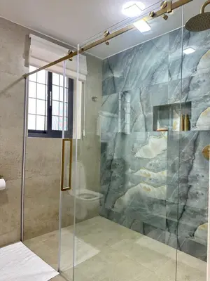 a shower with a glass door in a bathroom at French Unit - ground floor sleeps 2 in Arusha