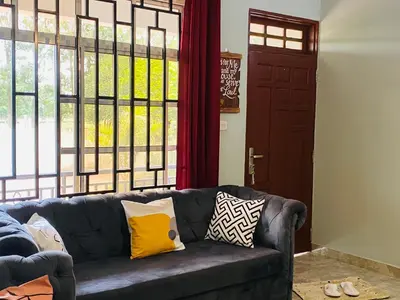 a living room with a couch with pillows on it at Tulivu Nyumba in Arusha