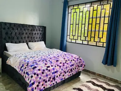 a bedroom with a bed and a stained glass window at Tulivu Nyumba in Arusha