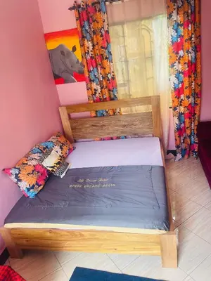 a bedroom with a wooden bed in a room at Moshi -Mnazi home stay in Moshi