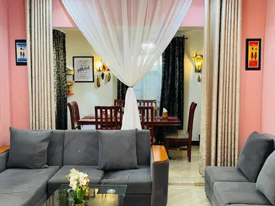a living room with a couch and a dining room at Moshi -Mnazi home stay in Moshi