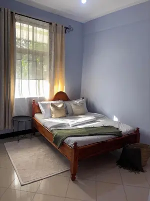 a bed in a room with a window at Cozy and stylish apartment in Arusha Town in Arusha