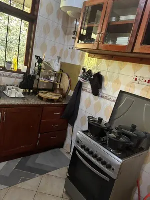 a kitchen with a stove with pots and pans on it at Cozy and stylish apartment in Arusha Town in Arusha