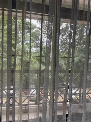 a view from inside a window with curtains at Cozy and stylish apartment in Arusha Town in Arusha